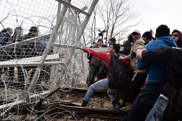 پناهجویان در حال از بین بردن حصار در مرز یونان - مقدونیه - اسپوتنیک ایران  