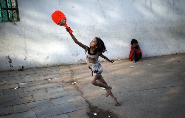 دختری در حال بازی بدمینتون در یکی از خیابان های دهلی - اسپوتنیک ایران  