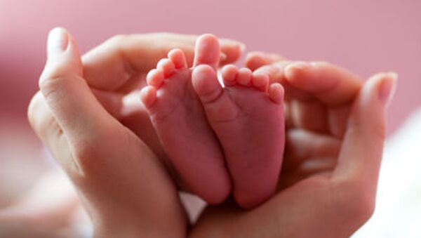 Ноги младенца в руках матери - اسپوتنیک ایران  