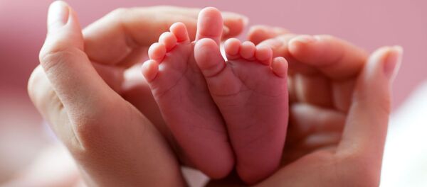 Ноги младенца в руках матери - اسپوتنیک ایران  