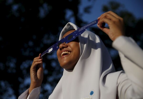 دختر دانش اموزی در کوالالامپور خورشید گرفتگی را تماشا می کند - اسپوتنیک ایران  