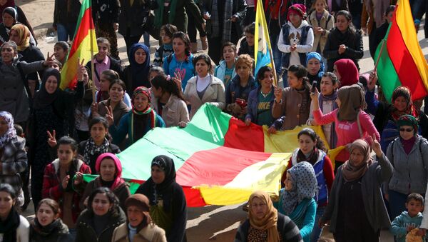 Kurdish people carry flags as they march during a protest in the city of al-Derbasiyah, on the Syrian-Turkish border, against what the protesters said were the operations launched in Turkey by government security forces against the Kurds, February 9, 2016 - اسپوتنیک ایران  