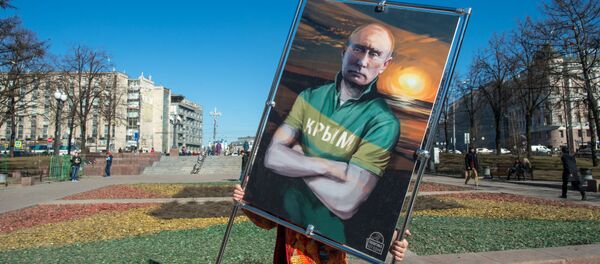 Человек несет картину, изображающую президента России Владимира Путина в футболке с надписью Крым - اسپوتنیک ایران  