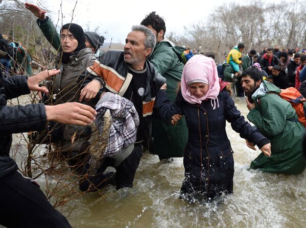 پناهجویان هنگام گذشتن از رودخانه در حال رسیدن به مقدونیه - اسپوتنیک ایران  
