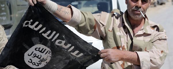 Сирийский солдат держит флаг ДАИШ Сирийский солдат держит флаг ДАИШ - اسپوتنیک ایران