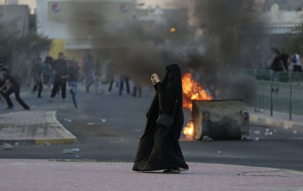 زنی در حال عکس گرفتن از  درگیری بین مردم و پلیس در بحرین - اسپوتنیک ایران  