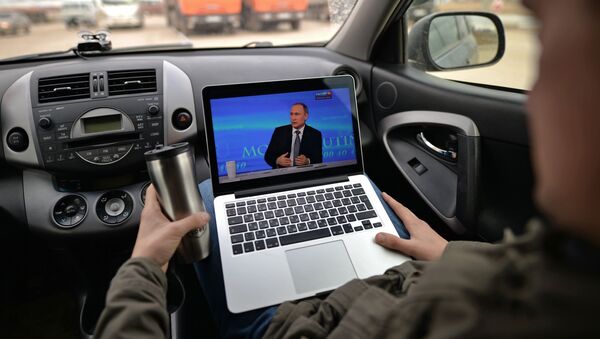 Пассажир смотрит трансляцию ежегодной специальной программы Прямая линия с Владимиром Путиным в автомобиле в Новосибирской области - اسپوتنیک ایران  