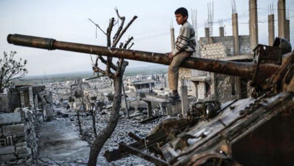 Курдский мальчик сидит на разрушенном танке в сирийском городе Кобани - اسپوتنیک ایران  