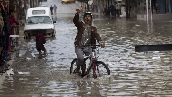 Молодой человек на велосипеде на затопленной улицу в городе Хан-Юнис, cектор Газа - اسپوتنیک ایران  