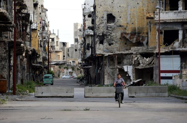 پسربچه سوری سوار بر دوچرخه در خیابان حمص - اسپوتنیک ایران  