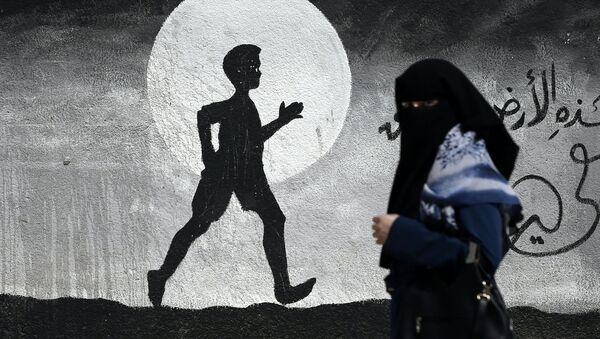 Палестинка проходит мимо граффити в Газе - اسپوتنیک ایران  