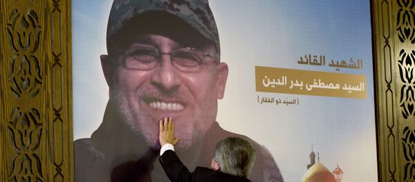 Adnan Badreddine, brother of top Hezbollah commander Mustafa Badreddine, grieves at his brother's picture in a southern suburb of Beirut, Lebanon - اسپوتنیک ایران  