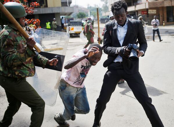 پلیس کنیا در حال زدن  معترض در زمان درگیری در نایروبی - اسپوتنیک ایران  