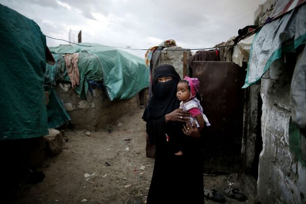 زن جوانی با کودکی در بغل  در کنار کلبه خانوادگی - اسپوتنیک ایران  