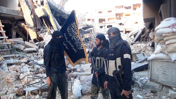 Fighters from the al-Qaida group in the Levant, Al-Nusra Front, stand among destroyed buildings near the front line with Syrian government solders in Yarmuk Palestinian refugee camp, south of Damascus on September 22, 2014 - اسپوتنیک ایران  