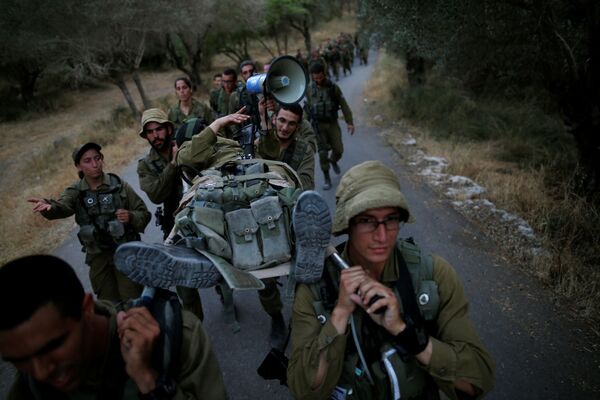سربازان اسرائیلی تیپ تجسس و امداد رسانی هنگام تمرینات در جنگل همقطار خود را با برانکارد حمل می کنند - اسپوتنیک ایران  