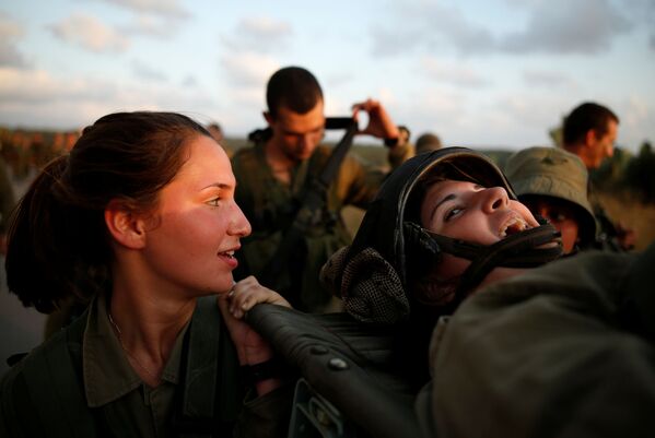 سربازان اسرائیلی تیپ تجسس و امداد رسانی هنگام تمرینات در جنگل همقطار خود را با برانکارد حمل می کنند - اسپوتنیک ایران  