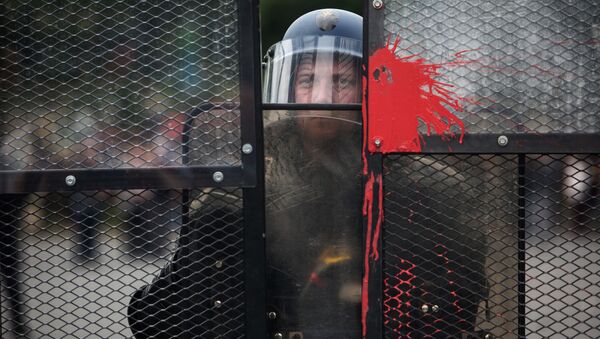 Полицейский стоит в оцеплении во время акции протеста профсоюзов в Париже - اسپوتنیک ایران  