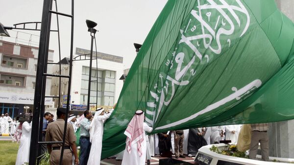 Saudi men unfurl a giant Saudi national flag during a ceremony to raise the highest flag in the country in the eastern city of Dammam on June 17, 2008 - اسپوتنیک ایران  