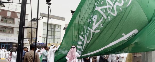 Saudi men unfurl a giant Saudi national flag during a ceremony to raise the highest flag in the country in the eastern city of Dammam on June 17, 2008 - اسپوتنیک ایران  