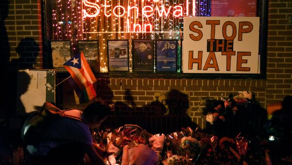 Shadows are cast on a wall as a man lights a candle at a memorial outside The Stonewall Inn on Christopher Street, considered by some as the center of New York State's gay rights movement, following the shooting massacre at Orlando's Pulse nightclub, in the Manhattan borough of New York, U.S., June 12, 2016. - اسپوتنیک ایران  