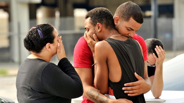 Friends and family members embrace outside the Orlando Police Headquarters during the investigation of a shooting at the Pulse night club, where as many as 20 people have been injured after a gunman opened fire, in Orlando, Florida, U.S June 12, 2016 - اسپوتنیک ایران  