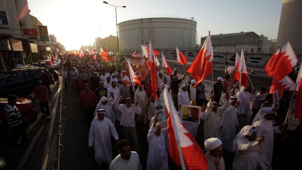 A few thousand Bahrainis wave national flags and carry pictures of political prisoners during a protest march in Sitra, Bahrain, Friday, Sept. 12, 2014 - اسپوتنیک ایران  