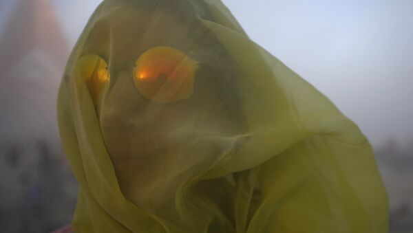 Meryl Livermore covers her head with a scarf during a dust storm at the Burning Man 2015 Carnival of Mirrors arts and music festival in the Black Rock Desert of Nevada, September 2, 2015 - اسپوتنیک ایران  