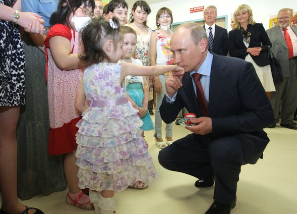 ولادیمیر پوتین نخست وزیر روسیه ( سال 2011) در حال بوسیدن دست دختر خردسال - اسپوتنیک ایران  