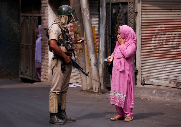پلیس در حال بازرسی اوراق شناسایی زن هندی در زمان حکومت نظامی در « سرینگر» هند - اسپوتنیک ایران  