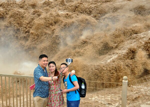 گردشگران در حال عکاسی در زمینه آبشار « هوکو» چین - اسپوتنیک ایران  