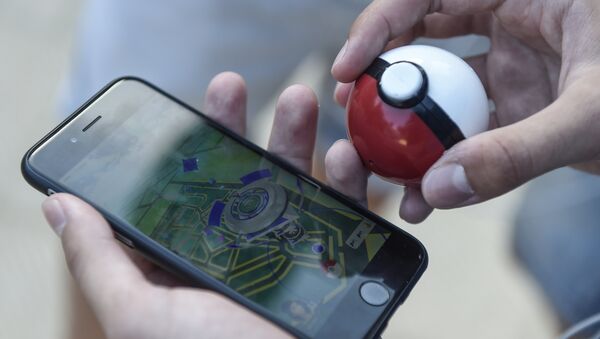 A gamer uses the Pokemon Go application on his mobile phone in a Barcelona park, on July 14, 2016. - اسپوتنیک ایران  