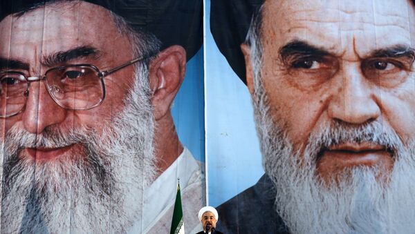 Iranian President Hassan Rouhani delivers a speech under portraits of Iran's supreme leader, Ayatollah Ali Khamenei (L) and Iran's founder of the Islamic Republic, Ayatollah Ruhollah Khomeini (R), on the eve of the 25th anniversary of the Islamic revolutionary leader Ayatollah Ruhollah Khomeini's death, at his mausoleum in a suburb of Tehran - اسپوتنیک ایران  