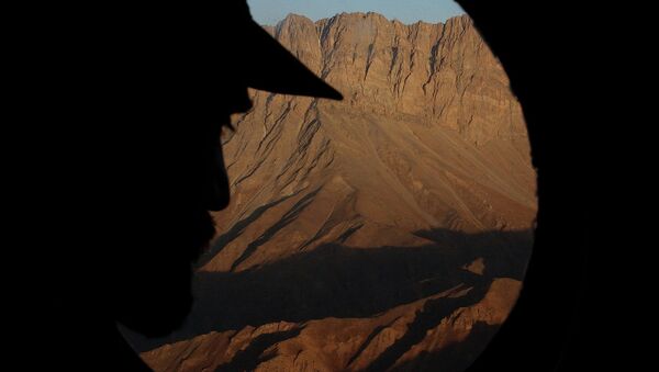Афганский офицер смотрит в иллюминатор вертолета, пролетая над районом Дарваза, граничащим с Таджикистаном. Архивное фото - اسپوتنیک ایران  