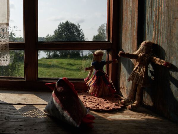 عروسک های قدیمی پشت پنجره خانه چوبی  در  روستای «ماندروگی» منطقه لنینگراد - اسپوتنیک ایران  