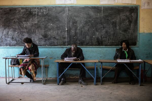 مأموران حزب سیاسی  در حال بررسی فهرست انتخاب کنندگان  در زامبیا - اسپوتنیک ایران  