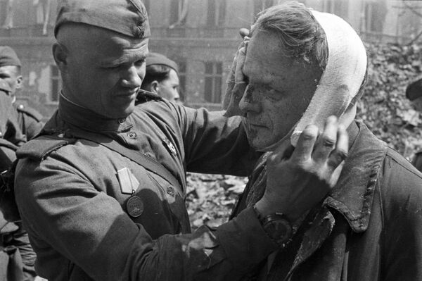 سرباز شوروی در حال پانسمان یک مجروح - اسپوتنیک ایران  