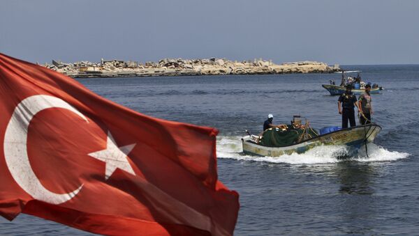 A Turkish flag hangs in the Gaza port as fishermen in their boats pass off the shore of Gaza City, Tuesday, Sept. 13, 2011 - اسپوتنیک ایران  