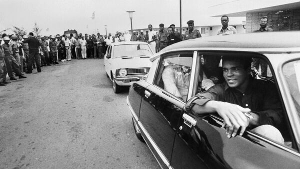 This file photo taken on September 28, 1974 shows former world heavyweight champion Muhammad Ali being welcomed by a cheering crowd in Kinshasa, Zaire, before his world heavyweight championship fight against titleholder US George Foreman on October 30, 1974 - اسپوتنیک ایران  