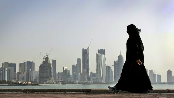 A Qatari woman walks in front of the city skyline in Doha, Qatar. - اسپوتنیک ایران  