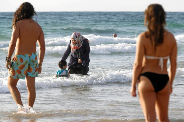 زن مسلمان در حال آبتنی دادن فرزندش در  دریای مدیترانه در اسرائیل - اسپوتنیک ایران  