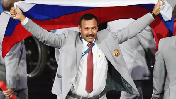 Директор Республиканского центра олимпийской подготовки по легкой атлетике Андрей Фомочкин с флагом России на церемонии открытия XV летних Паралимпийских игр 2016 в Рио-де-Жанейро - اسپوتنیک ایران  