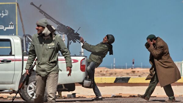 Боец оппозиции стреляет из пулемета в истребитель в городе Рас-Лануф в Ливии - اسپوتنیک ایران  