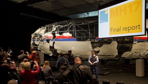 Часть реконструированного сбитого лайнера Boeing 777 Malaysia Airlines рейса MH17 на докладе об обстоятельствах его гибели на Востоке Украины 17 июля 2014 года на военной базе Гилзе-Рейен в Нидерландах - اسپوتنیک ایران  