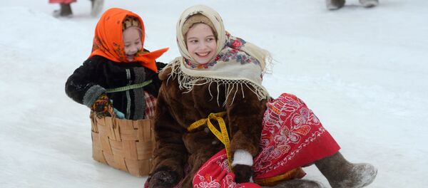 Девочки катаются на горке на открытии Масленичной недели на территории музея деревянного зодчества Малые Корелы в Архангельской области Девочки катаются на горке на открытии Масленичной недели на территории музея деревянного зодчества Малые Корелы в Архангельской области - اسپوتنیک ایران