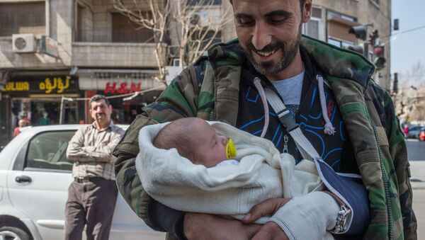 Мужчина с грудным ребенком на улице Дамаска в первый день перемирия - اسپوتنیک ایران  
