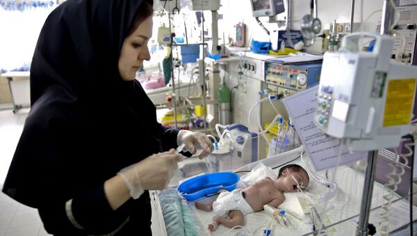 In this Monday, Dec. 30, 2013 photo, a nurse cares for a newborn baby in the Neonatal Intensive Care Unit of the Mofid Children Hospital in Tehran, Iran - اسپوتنیک ایران  