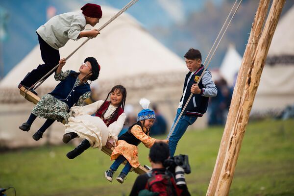 بچه ها در حال تاب بازی در شهرک قومی در تنگه « کرچین»  « ایسیک قول» قرقیزستان که در چارچوب دومین مسابقه جهانی کوچ نشینان -2016 افتتاح شد - اسپوتنیک ایران  