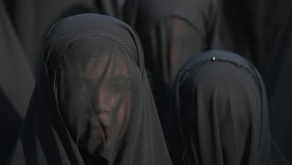 An Iraqi Shiite girl, whose face is covered with a veil, takes part in a parade in preparation for the peak of the mourning period of Ashura in Baghdad's northern district of Kadhimiya on October 22, 2015 - اسپوتنیک ایران  