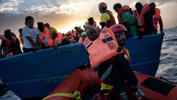 Спасение ребенка с терпящего бедствие судна с мигрантами в Средиземном море - اسپوتنیک ایران  